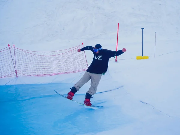 Russland, Sotschi 11.05.2019. Der Typ hob die Nase des Snowboards nach oben und fährt eine schöne Finte auf seinem Schwanz auf dem Wasser. Snowboard-Wettbewerb auf dem Wasser im Skigebiet Krasnaja Poljana. — Stockfoto