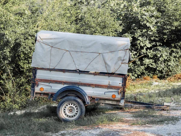 Güneşli bir yaz gününde, yeşil çalıların arka planında iki tekerlekli bir karavan duruyor. — Stok fotoğraf