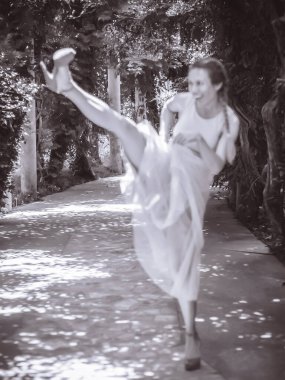 Yüksek topuklu kadın sokakta tekme atıyor. Bulanık etki. Siyah beyaz fotoğraf. Bulanık resim