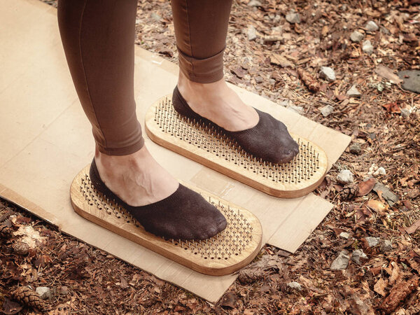 Ноги в леггинсах и черных носках стоят на острых шипах. Правление Садху