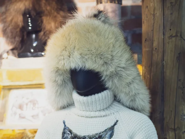 Zwarte vrouwelijke etalagepop gekleed in een warme bont wintermuts en gebreide trui in een winkel — Stockfoto