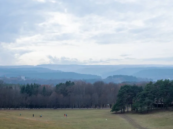 Uma clareira com atletas treinando nela cercada por árvores de outono em um vale montanhoso contra um céu nublado. Parque Nacional de Kislovodsk — Fotografia de Stock