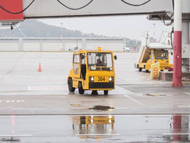 Rusya, Soçi 02.11.2021. Sarı forklift yağmurlu bir günde havaalanında gezintiye çıkar.
