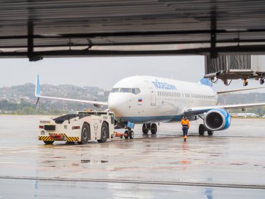 Rusya, Soçi 02.11.2021. Bir havaalanı römorkörü, üzerinde zafer yazan bir uçağa bağlı havaalanında duruyor..