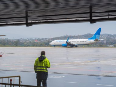 Rusya, Soçi 02.11.2021. Üzerinde yazılı zaferi olan beyaz-mavi bir uçak bulutlu bir havada hava sahasından kalkmaya hazırlanıyor. Kalkışa izin var. Seçici odak