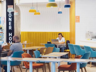 Rusya, Soçi 02.11.2021. Laptoplu bir kadın bir kafede masada oturuyor. Havaalanı kafe ziyaretçileri kalkış için bekliyorlar. Yumuşak odak
