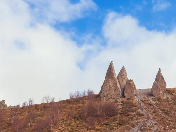 Острые каменные скульптуры, напоминающие клыки, расположены на вершинах гор у подножия Кавказа осенью ноябрьского дня. — стоковое фото