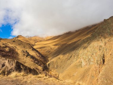 Sonbahar güneşiyle aydınlanan kalın beyaz bir bulut dağın tepesine indi. Kafkas dağları.