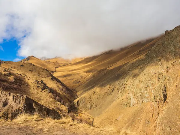 Sonbahar güneşiyle aydınlanan kalın beyaz bir bulut dağın tepesine indi. Kafkas dağları.