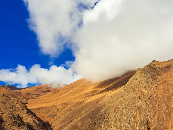 Sonbahar dağlarına beyaz bir bulut indi. Güneşin ışığında mavi gökyüzünün altında. Jily-su Vadisi