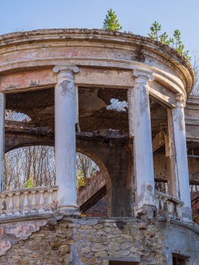 Kırık çatılı, boş pencereli ve ağaçlarla kaplanmış terk edilmiş Yunan tarzı restoran binası.