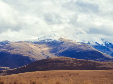 Kafkasya 'nın sonbahar aylarında tepeleri karla kaplanmış ve bulutlarla kaplanmış. İskoçya 'da keskin bir sıcaklık düşüşü.