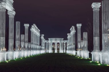 Rusya, Krasnodar 07.01.2022. Beyaz bir çerçeve, gece parkında yeşil bir sokak oluşturur.