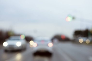 Farları açık arabalar bulutlu bir günde yolda ilerliyorlar. Bulanık fotoğraf
