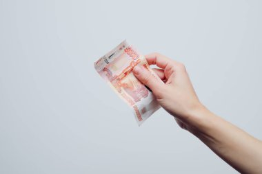 El, banknotu beyaz arka planda beş bin ruble değerinde tutuyor. Finans Konsepti
