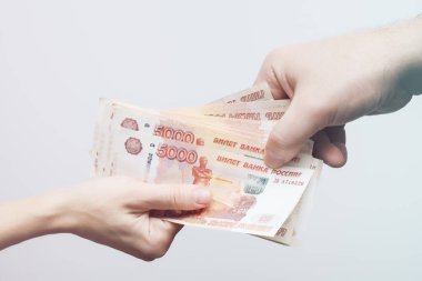 Bir kadın ve bir erkeğin elinde beş bin ruble değerinde bir deste banknot bulunur. Yumuşak odaklanma. Finans kavramı