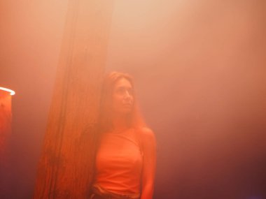 Athick Turuncu Gece Sisi 'nde bir kadın ağacın yanında duruyor. Bulanık görüntü ve gürültü