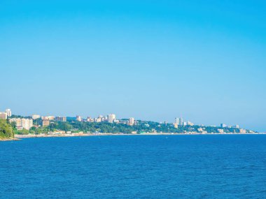 Açık bir yaz gününde, mavi denizin güney kıyısında. Uzakta kıyısı olan bir deniz manzarası.