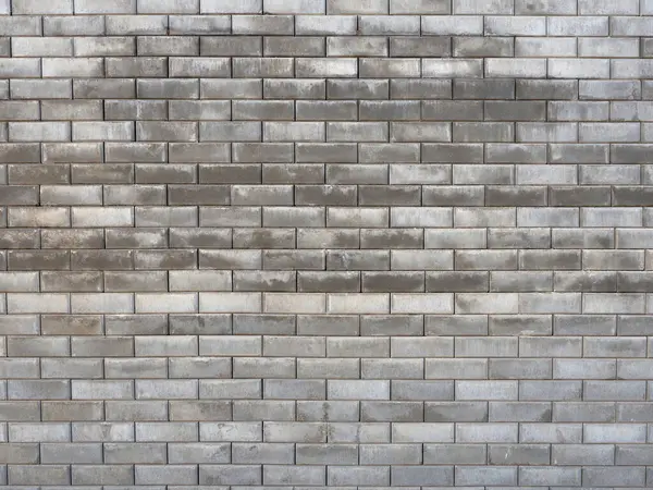 The outer wall of the building is made of gray bricks. Building without finishing. Full screen photo. Not seamless texture.