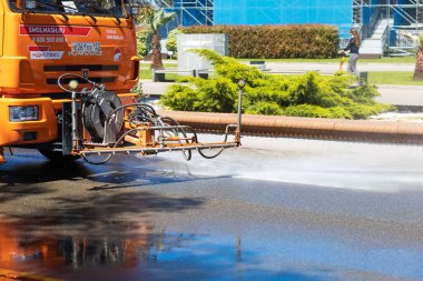 Rusya, Soçi 14.05.2022. Güneşli bir günde ferah bahar parkında fıskiye asfaltı yıkar..