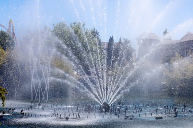 Çeşmenin göldeki fıskiyeleri etraftaki her şeyi suluyor. Lunaparktaki çeşme..