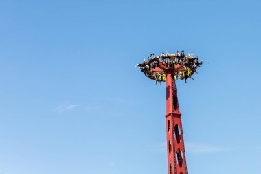 Rusya, Soçi 14.05.2022. Mavi gökyüzüne karşı tepetaklak sallanan devasa bir çekim gücü. Lunaparkta adrenalin eğlencesi