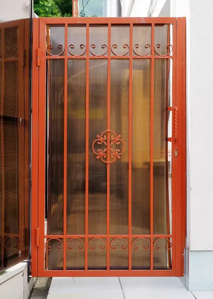 Forged patterned lattice on the gate of the house. Entrance to private area.