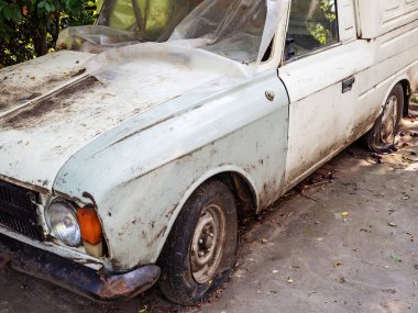 Lastikleri patlak, kirli, eski model bir araba polietilen kaplı.