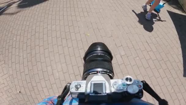 俄罗斯 索契2022年5月28日 摄影师脖子上戴着照相机走路 一个摄影师带着相机在阳光灿烂的日子里走在铺路板上 第一人称观点 — 图库视频影像