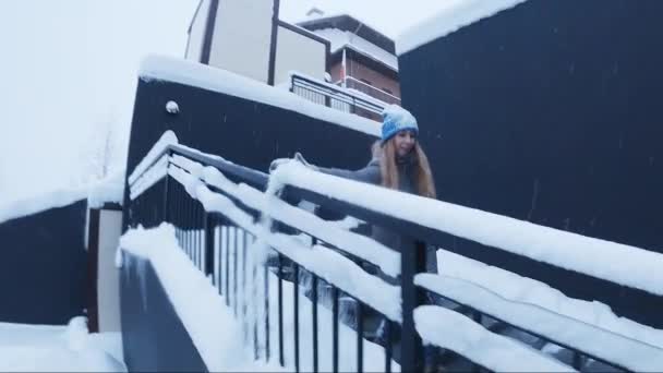 Wanita Menggosok Salju Dari Pagar Wanita Berjalan Menyusuri Jalan Langkah — Stok Video