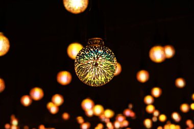 Yuvarlak şeffaf bir ampul ve içinde birçok renkli ışık var. Seçici odak