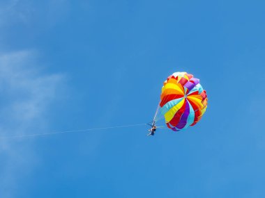 İki turist renkli bir paraşütle uçuyor.