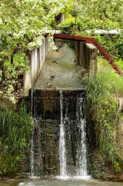 Su, beton kanalından nehre akıyor.