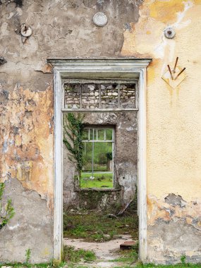 Terk edilmiş eski bir binanın kırık penceresinin kapısından bak