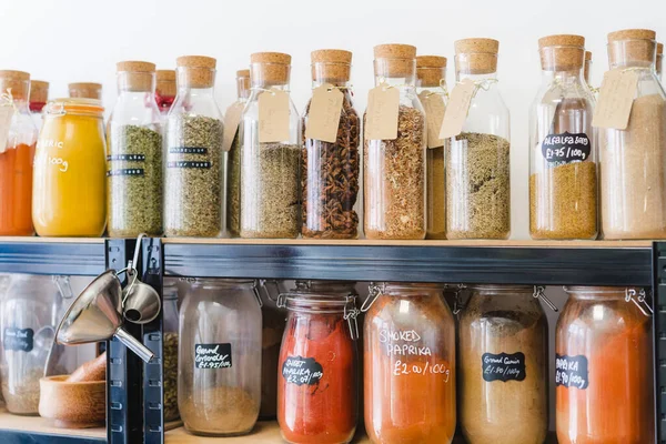 Eco-friendly zero waste shop. Glass bottles, jars with herbs and spices in sustainable plastic-free grocery store. Bio organic food. Shopping at small local businesses. New trend alternative buying