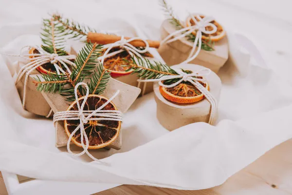 Eco-friendly, Zero-waste gift boxes decorated with spruce and dried orange. Handmade presents. Christmas time, no plastic package ideas. — Stock Photo, Image