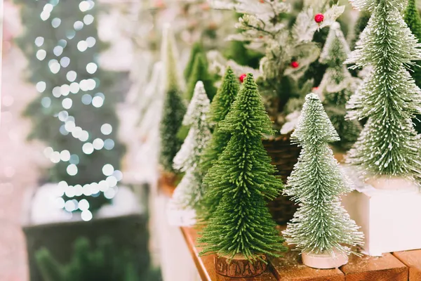 Árboles artificiales decorativos de Navidad y Año Nuevo en el mostrador de la tienda en el mercado de Navidad. Preparándose para las vacaciones de invierno. Enfoque selectivo. — Foto de Stock