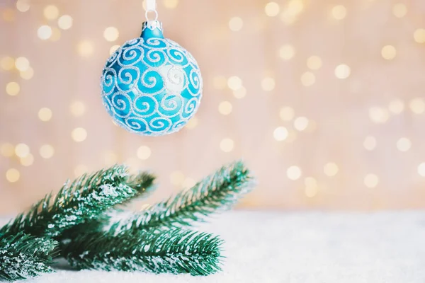 节庆构图与杉树枝条，蓝色装饰的球装饰在雪地上的温暖灯光下防波堤背景。圣诞快乐，新年快乐。复制空间。有选择的重点 — 图库照片
