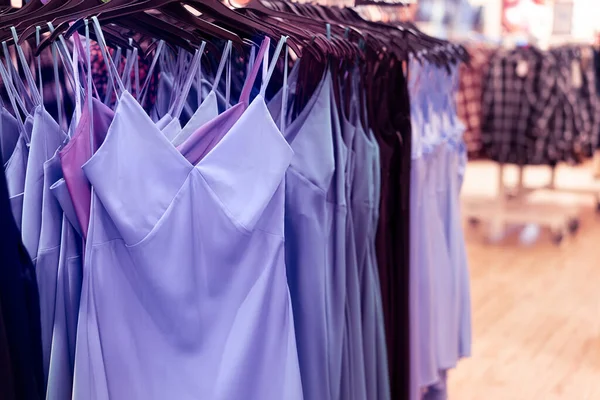 Bardzo liliowe sukienki na wieszaki w sklepie, butik. Trend kolor 2022. Centrum handlowe. Sprzedaż. Centrum handlowe. Wybiórcze skupienie. Miejsce na tekst — Zdjęcie stockowe