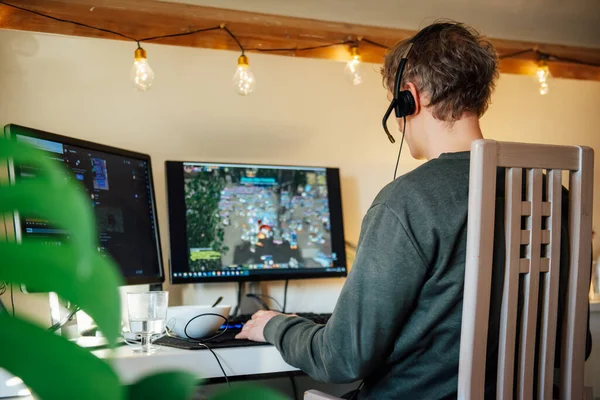 Der Mann mit dem Headset spielt Videospiele auf seinem Desktop-PC. Online-Zeit, virtuelles Leben, Spielsucht. Selektiver Fokus — Stockfoto