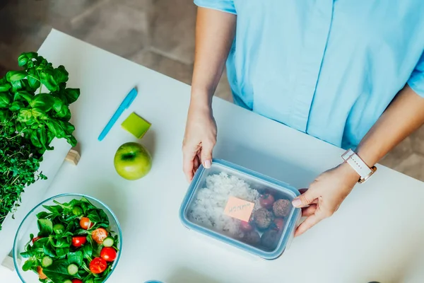 Healthy diet plan for weight loss, daily ready meal menu. Close up woman putting note on lunch box cooked in advance, ready to eat for lunch. Balanced portion with healthy dish. Pre-cooking concept — Stock Photo, Image
