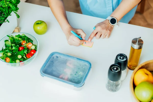 Régime alimentaire sain pour la perte de poids, menu quotidien des repas prêts. Fermer femme mettre une note sur la boîte à lunch cuit à l'avance, prêt à manger pour le dîner. Partie équilibrée avec un plat sain. Concept de précuisson. — Photo