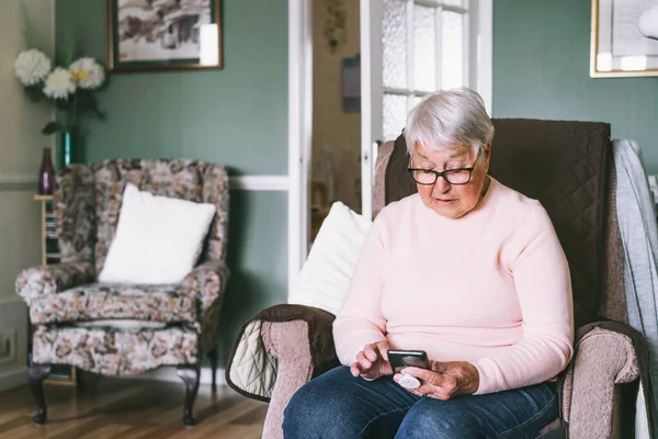 Mujer Mayor Usando Teléfono Inteligente Sentado Sillón Casa Relajado Señora —  Fotos de Stock