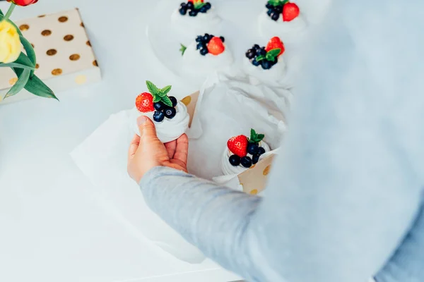 Woman Putting Pavlova Meringue Dessert Cake Fresh Strawberries Blueberries Decorated — Stockfoto