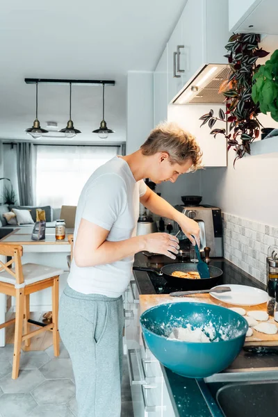 Young Man Cooking Cheese Pancakes Modern Light Kitchen Home Man — Stock Photo, Image