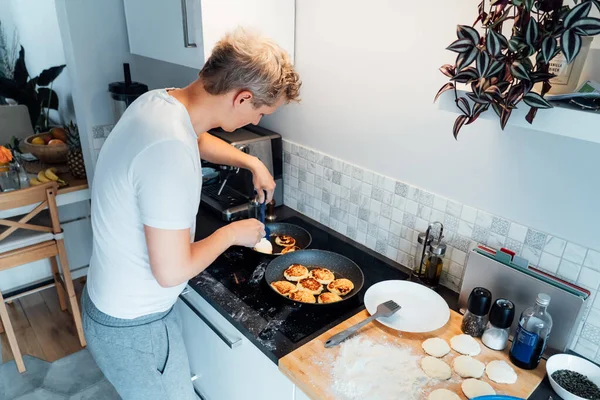 Young Man Cooking Cheese Pancakes Modern Light Kitchen Home Man — Stockfoto