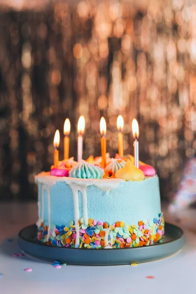 Kolorowy Tort Urodzinowy Posypką Palącymi Się Świecami Błyszczącym Złotym Tle — Zdjęcie stockowe