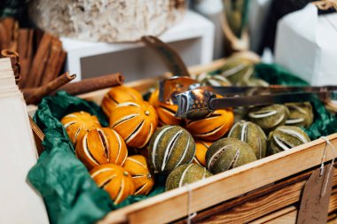Avrupa 'da Noel pazarı. Baharatlar ve meyve kompozisyonları. Tarçın çubukları, kurutulmuş portakallar ve tahta kutuda çelenk süslemesi için limon. Seçici odak