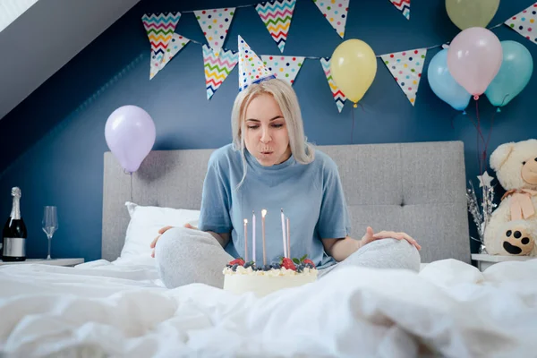 Happy Woman Pajama Party Cap Blowing Out Candles Birthday Cake — Foto Stock