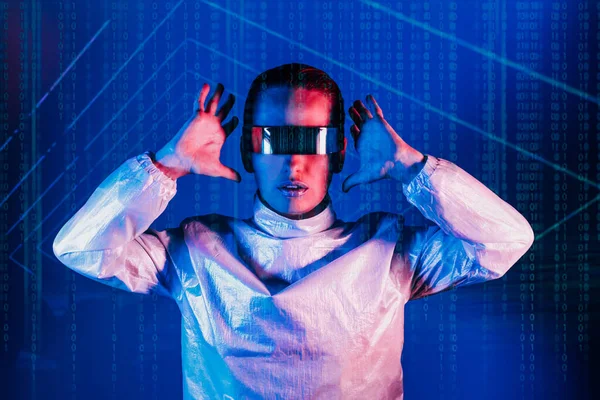 Woman, dressed in futuristic holographic clothes and eyeglasses with reflection of matrix code and matrix digital numbers artificial intelligence before her in blue light. Selective focus